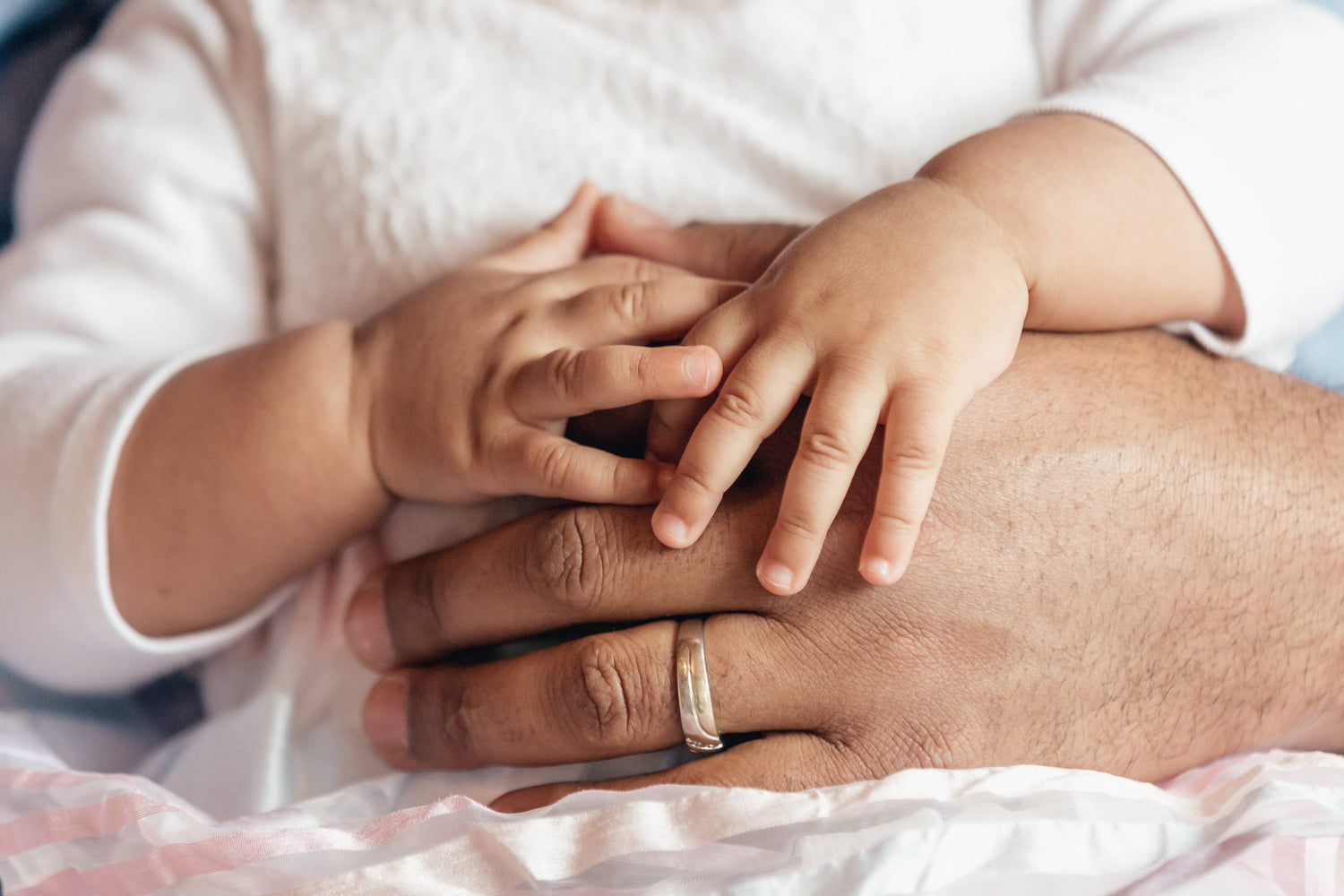 baby holding father's hand