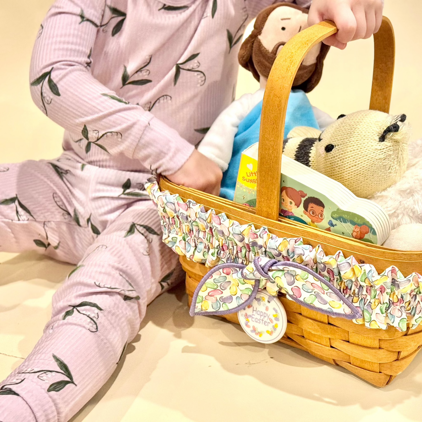 toddler in lily pattern PJs holding Easter basket