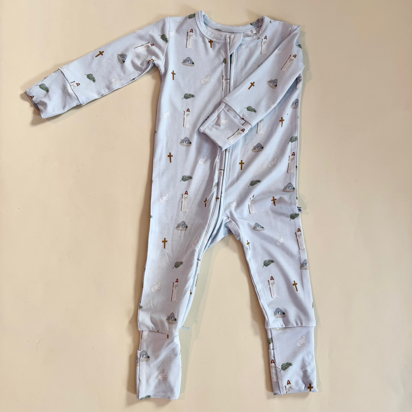 Baby onesie with Easter pattern on a beige background