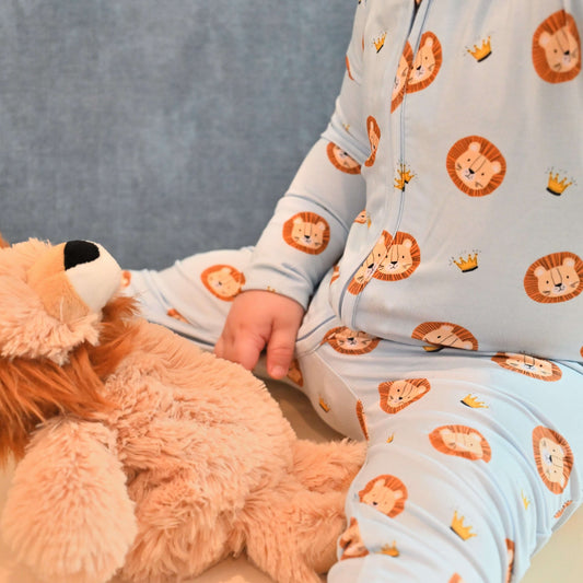 baby wearing lion pattern zip romper with stuffed lion