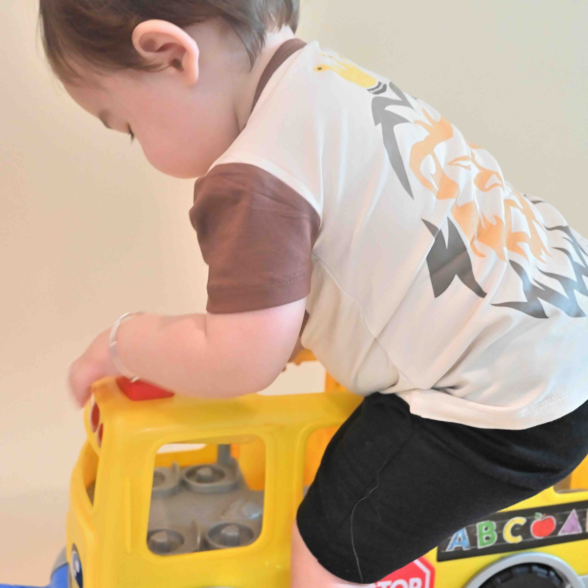 baby boy wearing lion print Jesus is King tee playing