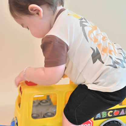 baby boy wearing lion print Jesus is King tee playing