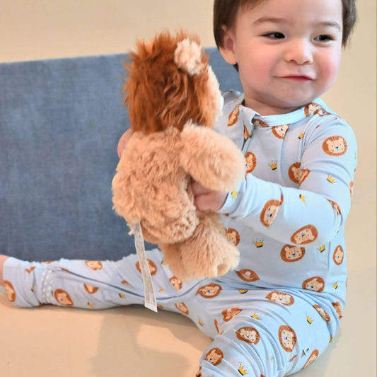 baby boy with stuffed lion wearing lion pattern zip romper