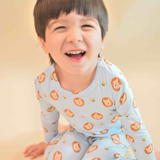 toddler boy smiling while wearing lion pajamas