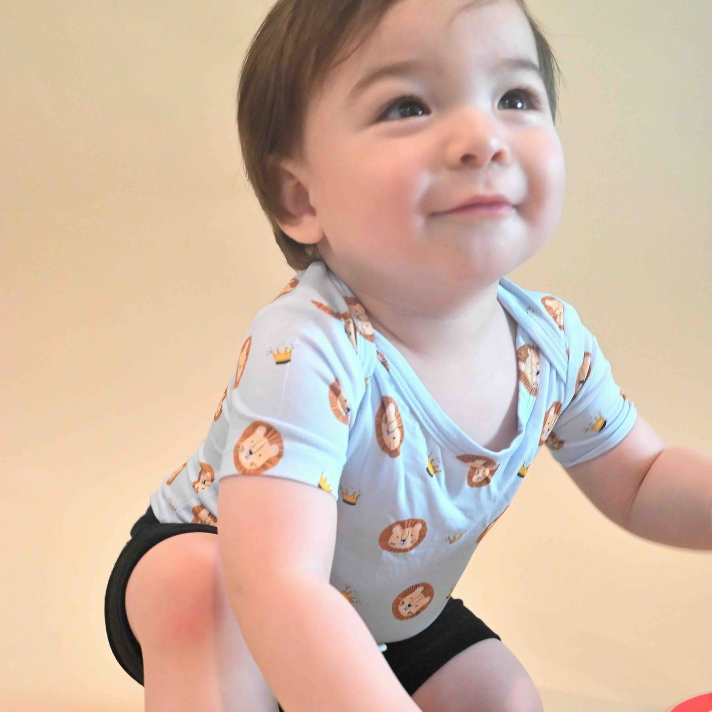 baby boy wearing lion and crown pattern onesie in blue