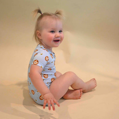 baby girl sitting while wearing lion onesie