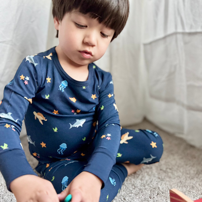 toddler boy in sea animal pattern pajamas playing